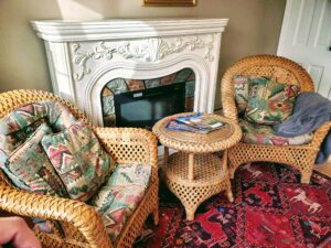 Living room area with sofa, end tables, fireplace, TV, and dinette for two.