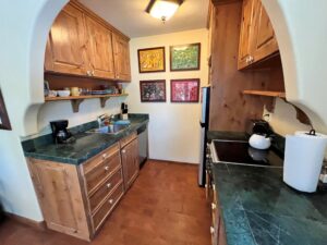 Compact kitchen with verde marble countertops, southwest pine cabinets and stainless appliances.