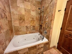 Travertine tiled shower surround with jetted tub.