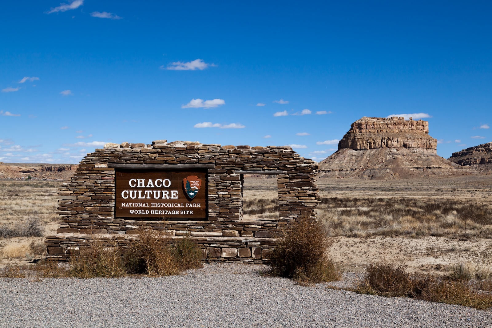 The Chaco Culture National Historical Park sign with ruins in the background